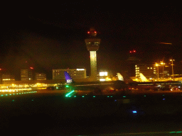 Airplanes and Control Tower at Schiphol Airport, viewed from the airplane, by night