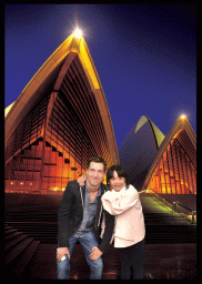 Postcard with Tim and Miaomiao in front of the Sydney Opera House, by night