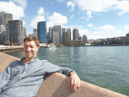 Tim at the Lower Concourse of the Sydney Opera House, with a view on the Sydney Cove, the Circular Quay Wharf, the Circular Quay Railway Station and skyscrapers at the city center