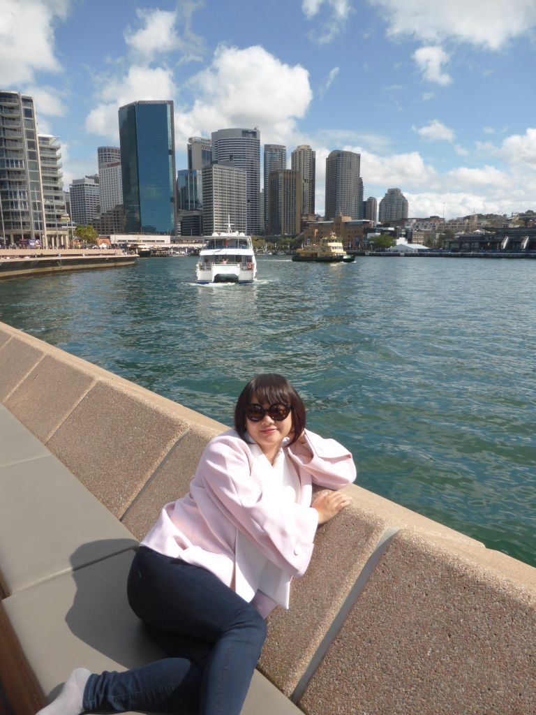 Miaomiao at the Lower Concourse of the Sydney Opera House, with a view on the Sydney Cove, the Circular Quay Wharf, the Circular Quay Railway Station and skyscrapers at the city center