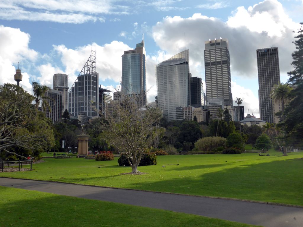 Grassland with trees and the copy of the Choragic Monument of Lysicrates and the Main Pond at the Royal Botanic Gardens, with a view on the Sydney Tower and other skyscrapers in the city center