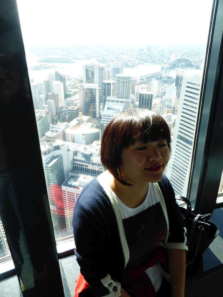 Miaomiao at the Sydney Tower, with a view on the skyscrapers in the city center and the Sydney Harbour Bridge over the Sydney Harbour