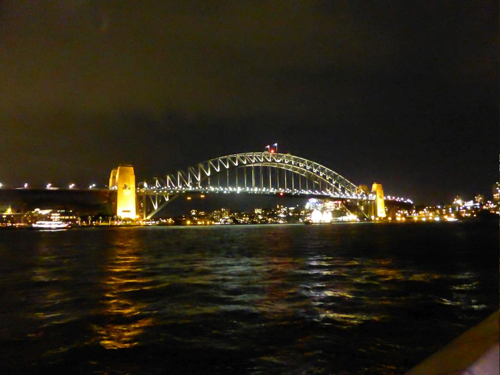 The Sydney Cove, the Sydney Harbour Bridge and Luna Park Sydney, viewed from the Lower Concourse of the Sydney Opera House, by night