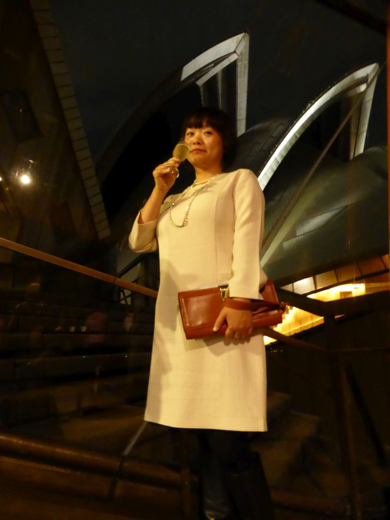 Miaomiao with a glass of wine at the Northern Foyer of the Joan Sutherland Theatre at the Sydney Opera House, with a view on the northwest side of the Sydney Opera House, by night