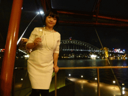Miaomiao with a glass of wine at the Northern Foyer of the Joan Sutherland Theatre at the Sydney Opera House, with a view on the Sydney Cove, the Sydney Harbour Bridge and Luna Park Sydney, by night