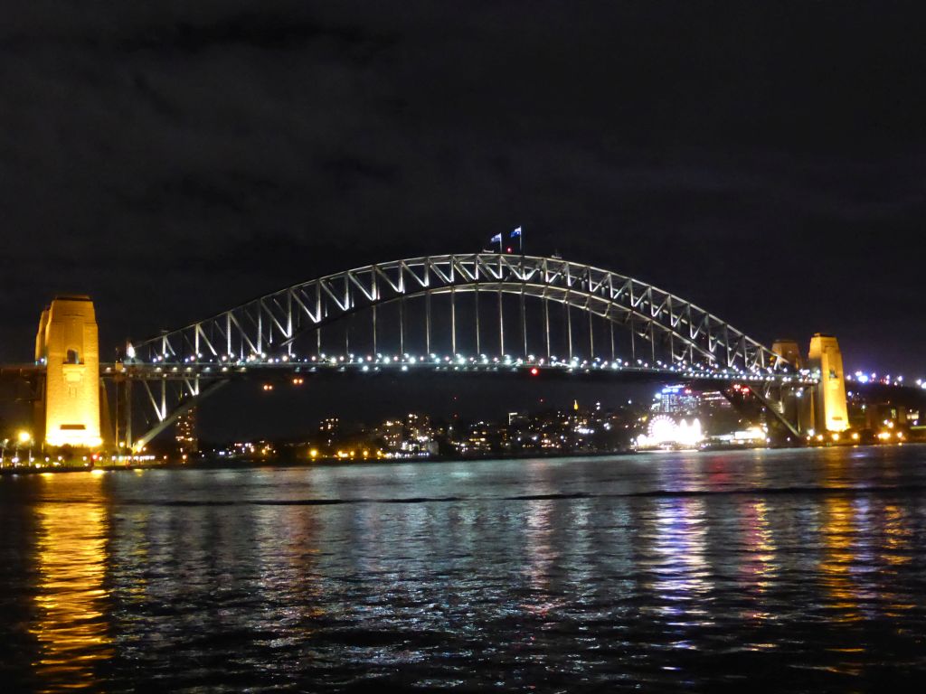 The Sydney Cove, the Sydney Harbour Bridge and Luna Park Sydney, viewed from the Lower Concourse of the Sydney Opera House, by night