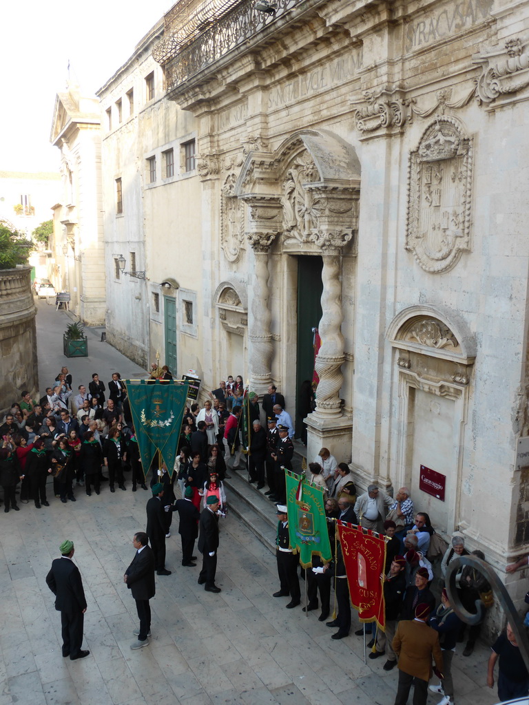 People preparing for the procession during the feast of St. Lucy in front of the Chiesa di Santa Lucia alla Badia church at the Piazza Duomo Square, viewed from the balcony of the Palazzo Borgia del Casale palace