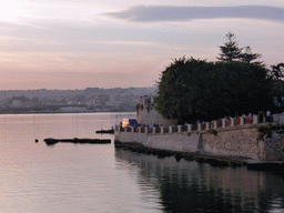 Path next to the Fonte Aretusa fountain and the Porto Grande harbour, viewed from the Lungomare Alfeo street, at sunset