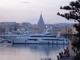 Boat in the Porto Grande harbour and the dome of the Santuario della Madonna delle Lacrime church, viewed from the viewpoint near the Fonte Aretusa fountain, at sunset