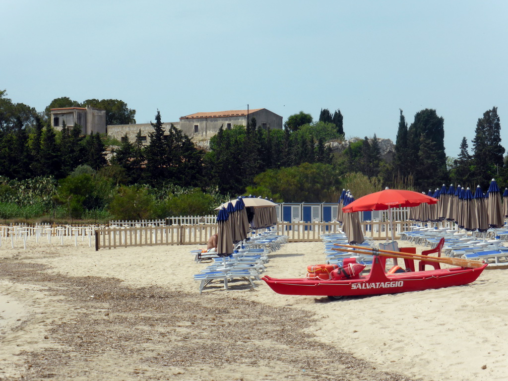 Building, sun chairs and boat at the Lido Sayonara beach at the village of Fontane Bianche