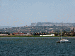 Boat in the Porto Grande harbour and buildings and hills on the other side of the Porte Grande harbour, viewed from the Lungomare Alfeo street