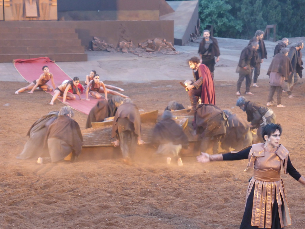 Clytemnestra, chorus, boat, female dancers and Agamemnon walking over the purple tapestry to the gates of Argos at the stage of the Greek Theatre at the Parco Archeologico della Neapolis park, during the play `Agamemnon` by Aeschylus