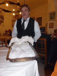 Waiter preparing salted fish at the Trattoria Archimede restaurant at the Via Mario Gemmellaro street