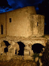 Southeast side of the Chiesa San Nicolò ai Cordari church and the Roman swimming pool at the Parco Archeologico della Neapolis park, by night