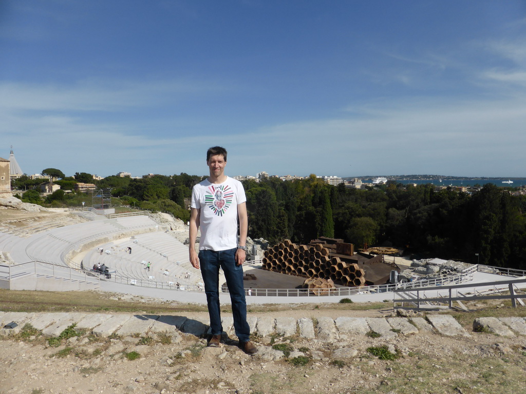 Tim at the Greek Theatre at the Parco Archeologico della Neapolis park, with the stage being prepared for the play `The Wasps` by Aristophanes, the Santuario della Madonna delle Lacrime church and the Porte Grande harbour