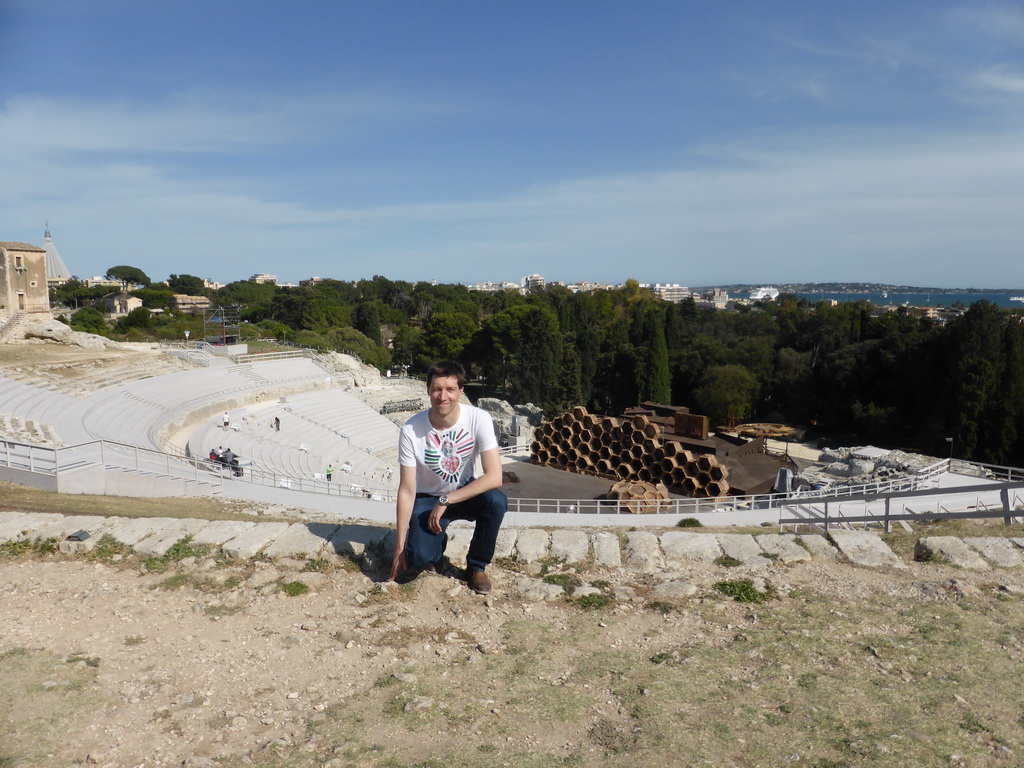 Tim at the Greek Theatre at the Parco Archeologico della Neapolis park, with the stage being prepared for the play `The Wasps` by Aristophanes, the Santuario della Madonna delle Lacrime church and the Porte Grande harbour