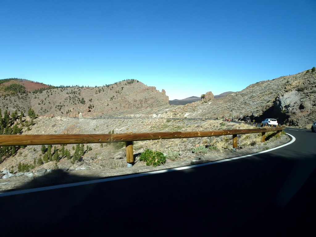 The TF-21 road, hills, rocks and trees on the southwest side of the Teide National Park, viewed from the rental car