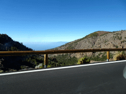 The TF-21 road, hills, rocks and trees on the southwest side of the Teide National Park, viewed from the rental car