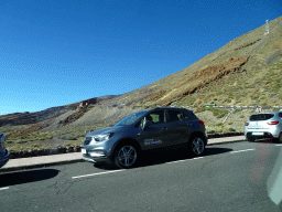 Cars parked in line on the road to the Teide Cable Car base station, viewed from the rental car