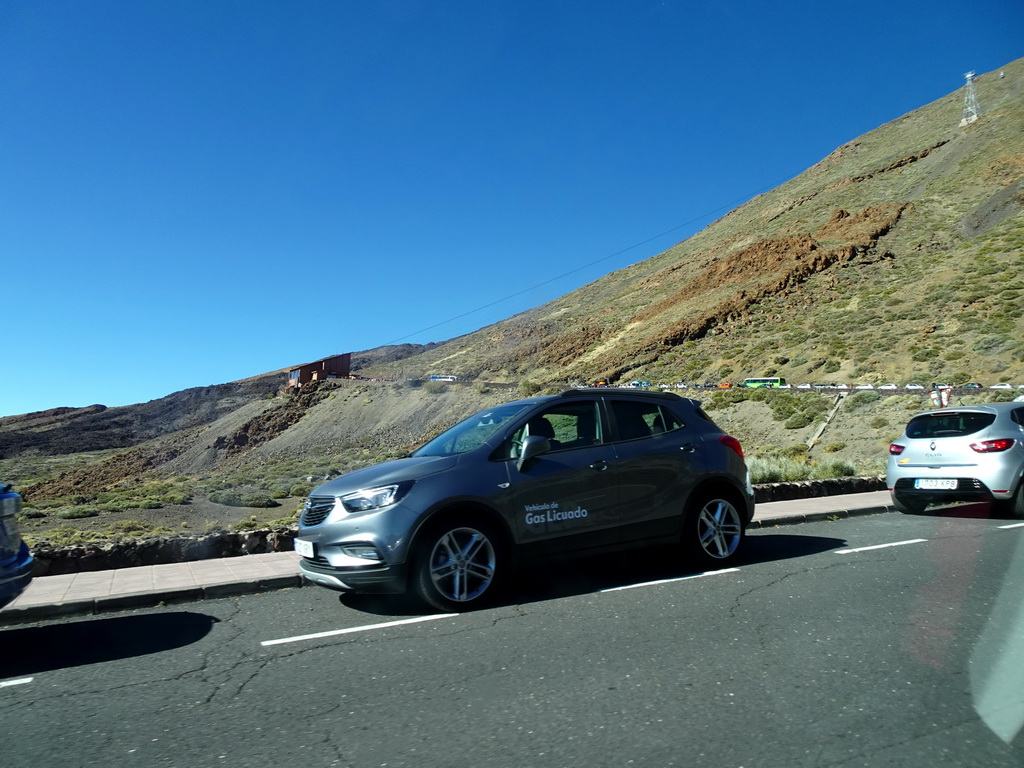 Cars parked in line on the road to the Teide Cable Car base station, viewed from the rental car