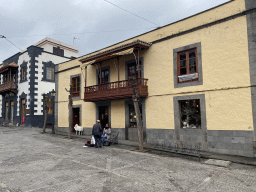 Street musician in front of a house with a wooden balcony at the Calle Real de la Plaza street