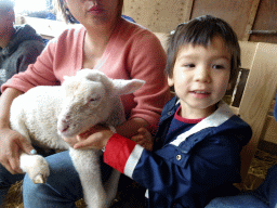 Miaomiao and Max cuddling a lamb at the Texel Sheep Farm at Den Burg