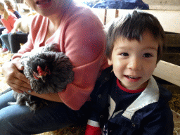 Miaomiao and Max cuddling a chicken at the Texel Sheep Farm at Den Burg