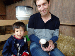 Tim and Max cuddling a chicken at the Texel Sheep Farm at Den Burg