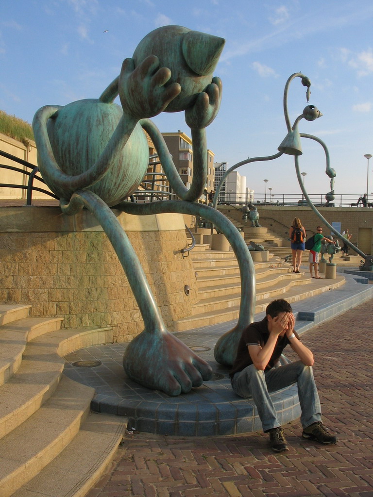 Tim with statues at the Strandweg street of Scheveningen