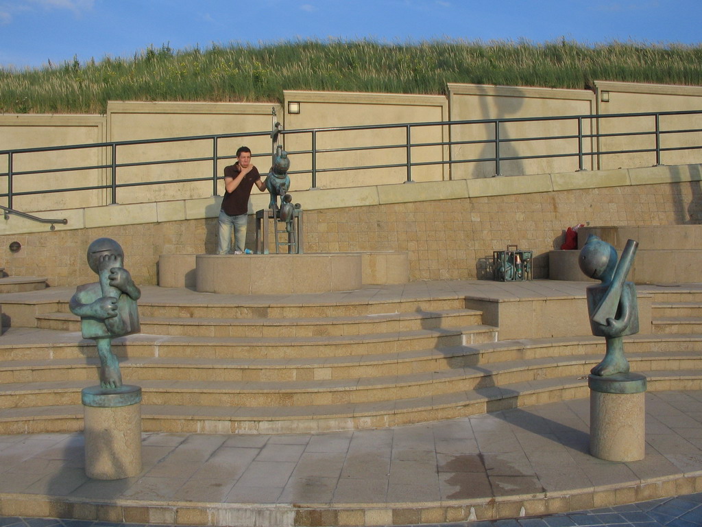 Tim with statues at the Strandweg street of Scheveningen