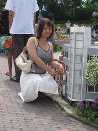 Miaomiao with a scale model of a C&A store at the Madurodam miniature park