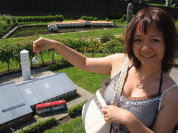 Miaomiao with miniature clogs in front of a scale model of the Klompenfabriek B. Roesink of Borne at the Madurodam miniature park