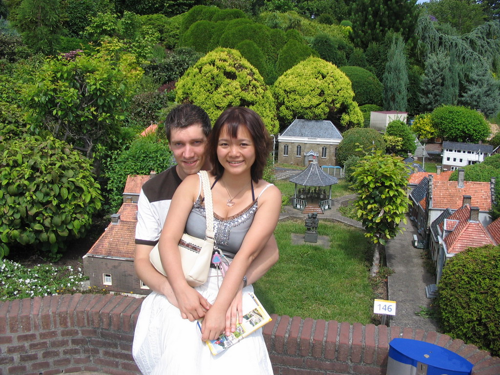 Tim and Miaomiao with scale models of a kiosk and other buildings at the Madurodam miniature park