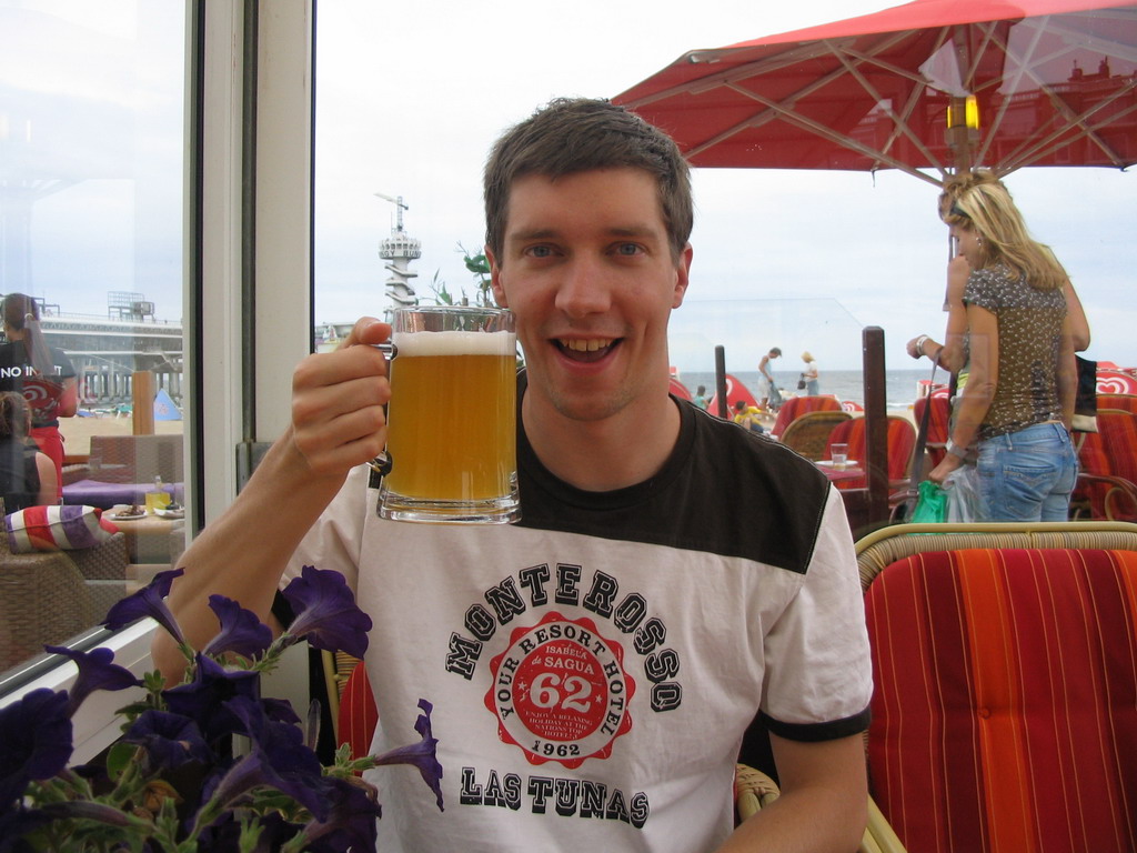 Tim with a beer at a beach pavilion at the Strandweg street of Scheveningen, with a view on the Pier of Scheveningen