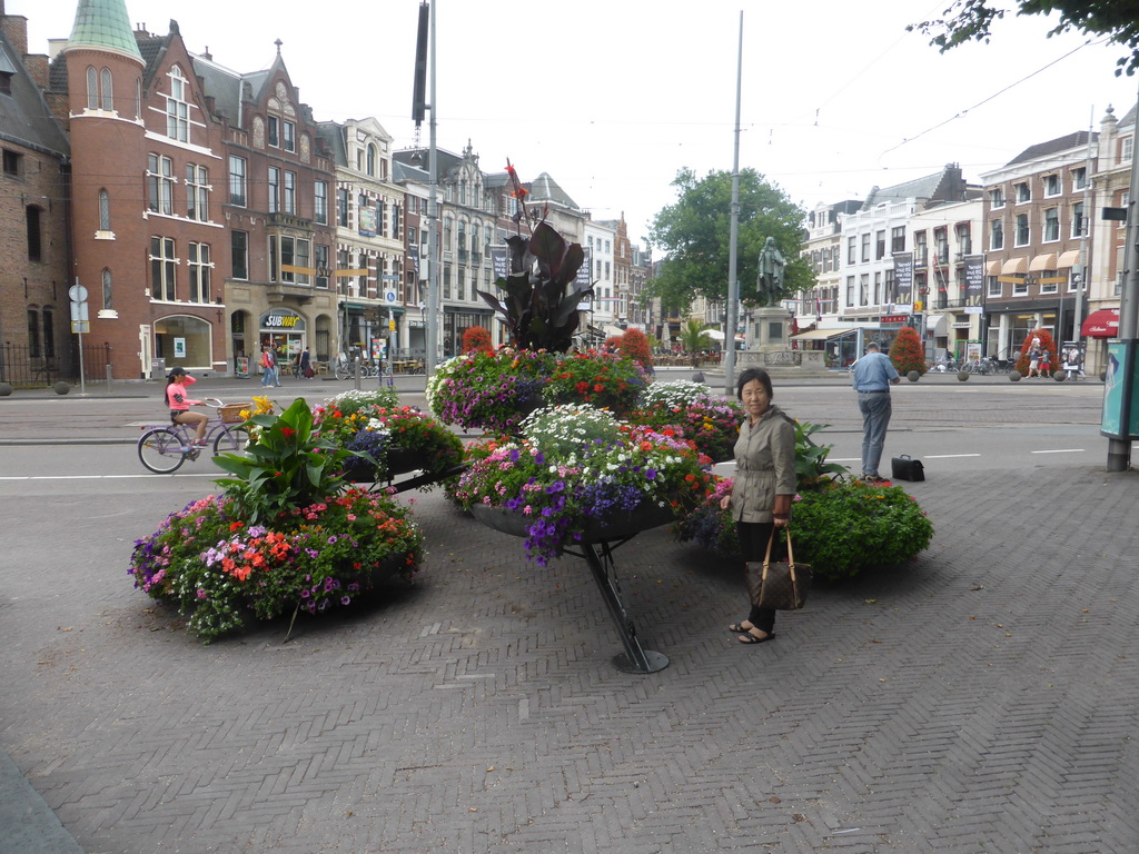 Miaomiao`s mother with flowers at the Binnenhof square and the statue of Johan de Witt at the Plaats square