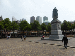 Miaomiao`s father at the Plein square with the statue of prince Willem I and the skyscrapers in the city center