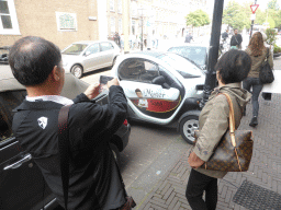 Miaomiao`s parents with a small electric car at the Heulstraat street