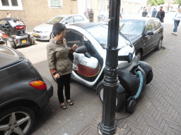 Miaomiao`s mother with a small electric car at the Heulstraat street