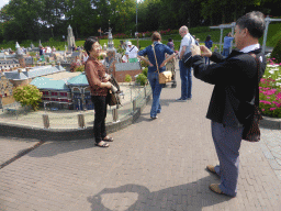 Miaomiao`s parents with the scale model of the Shopping center at the Dagelijkse Groenmarkt street of The Hague at the Madurodam miniature park
