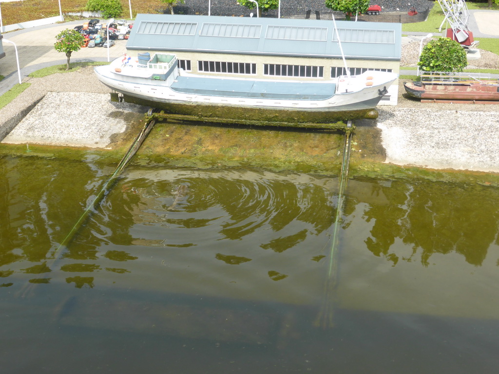 Scale model of a boat being lowered into the water at the Madurodam miniature park