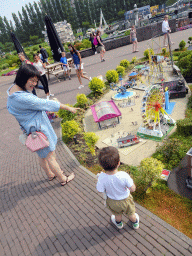 Miaomiao and Max in front of a scale model of a funfair at the Madurodam miniature park