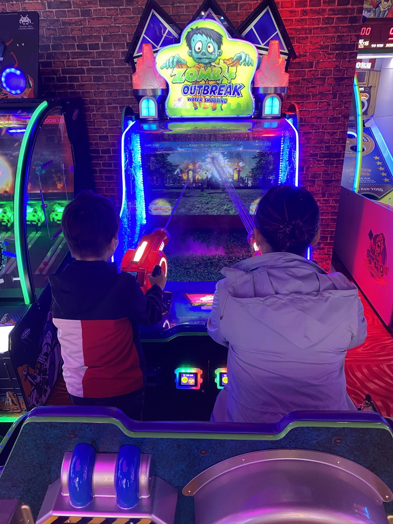 Miaomiao and Max playing a shooting game at the Sir Winston Fun & Games arcade