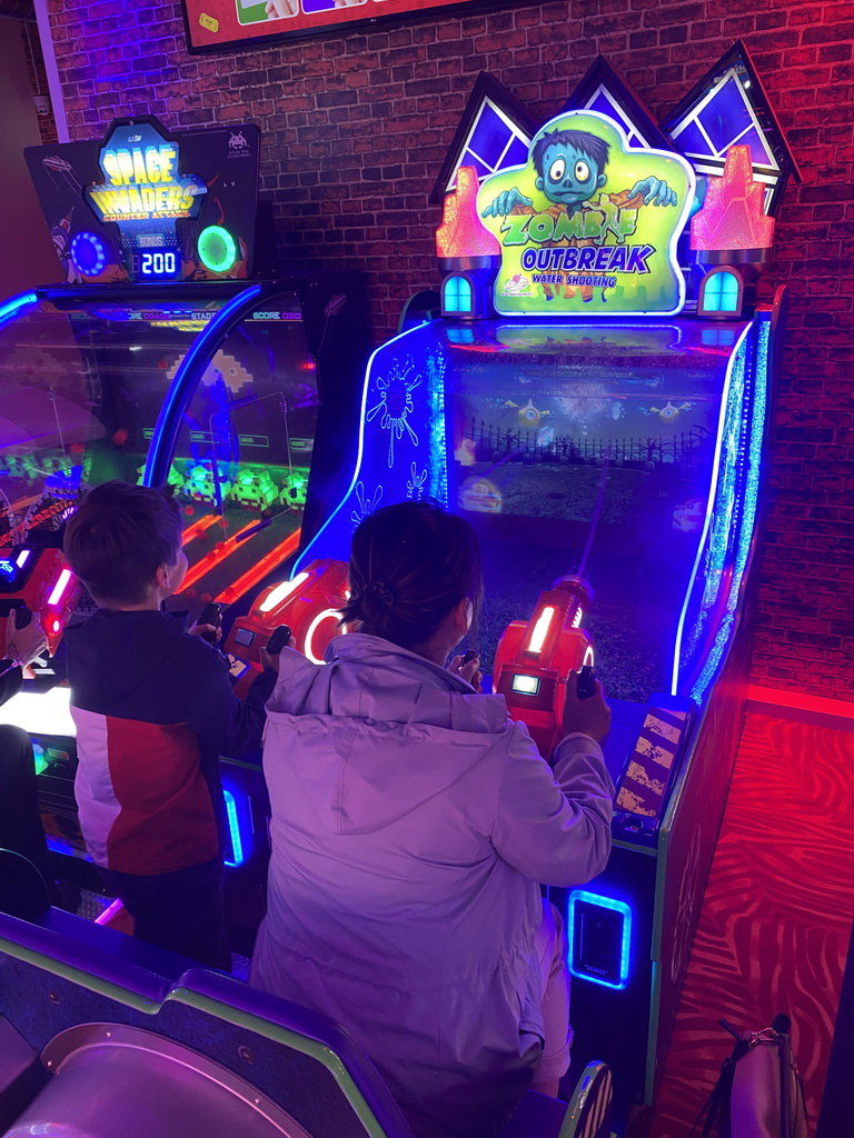 Miaomiao and Max playing a shooting game at the Sir Winston Fun & Games arcade