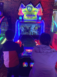 Miaomiao and Max playing a shooting game at the Sir Winston Fun & Games arcade