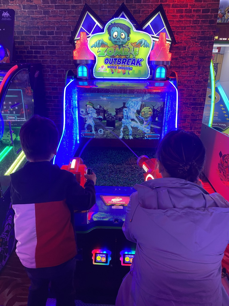 Miaomiao and Max playing a shooting game at the Sir Winston Fun & Games arcade