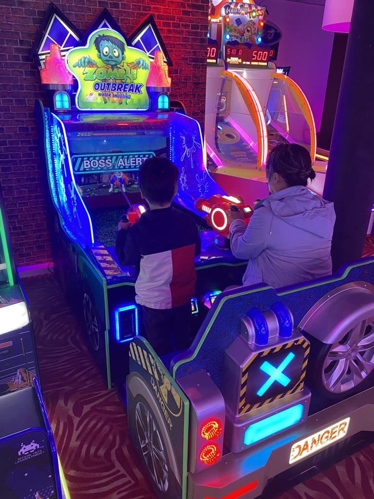 Miaomiao and Max playing a shooting game at the Sir Winston Fun & Games arcade