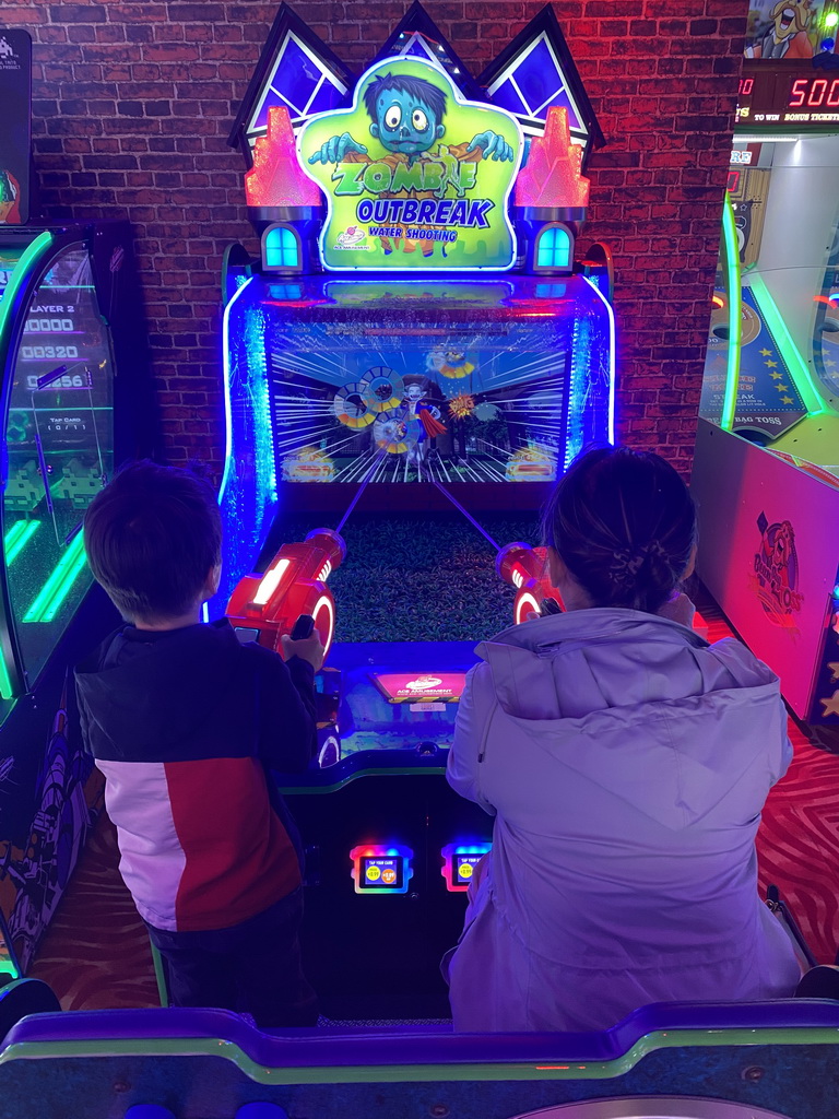 Miaomiao and Max playing a shooting game at the Sir Winston Fun & Games arcade