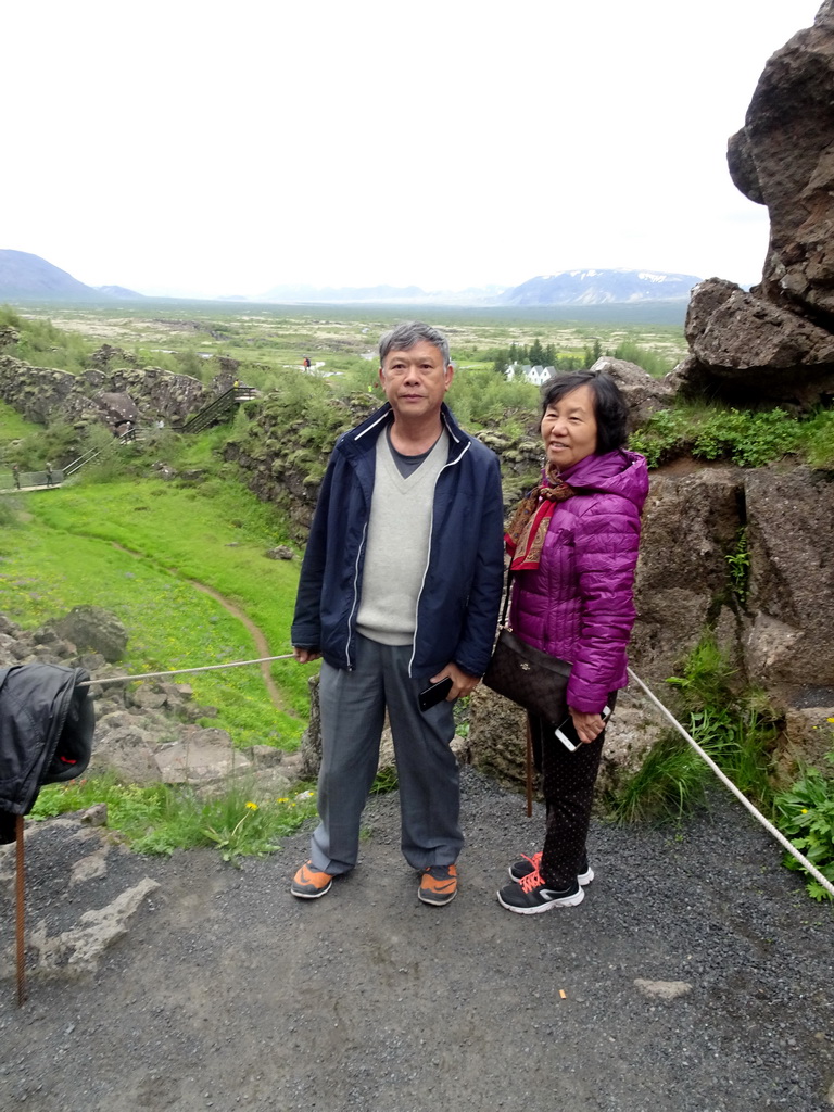 Miaomiao`s parents at the path through the Almannagjá Gorge, with a view on the Þingvellir National Park with the Þingvellir Church and houses