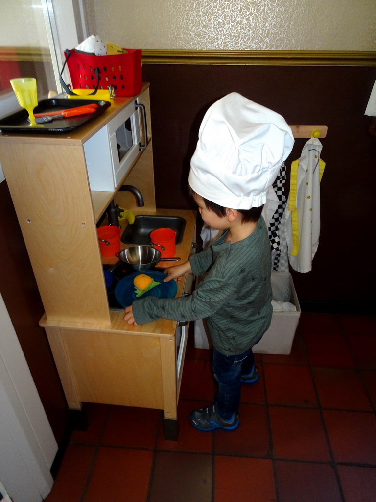 Max playing in the toy kitchen at the Pannekoekenbakker restaurant