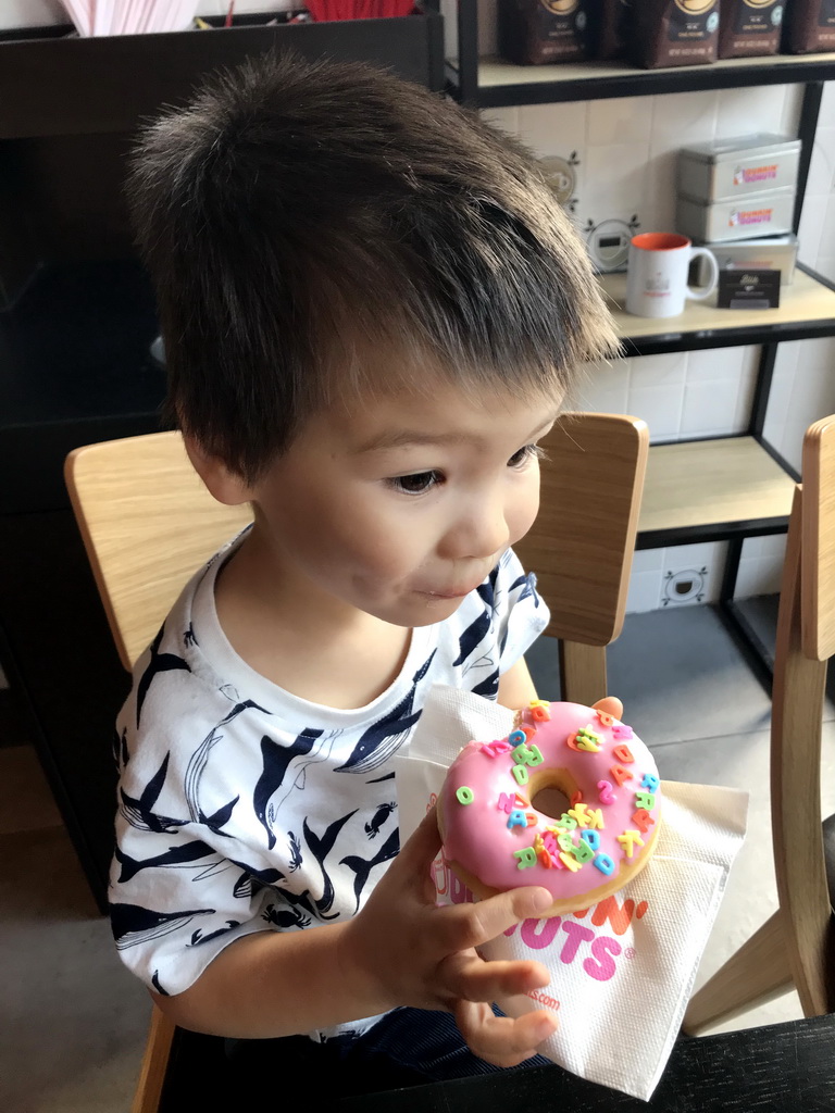 Max eating a donut at the Dunkin` Donuts restaurant at the Pieter Vreedeplein square